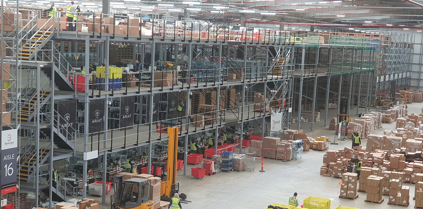 The interior of a large warehouse with several floors, boxes and warehouse equipment