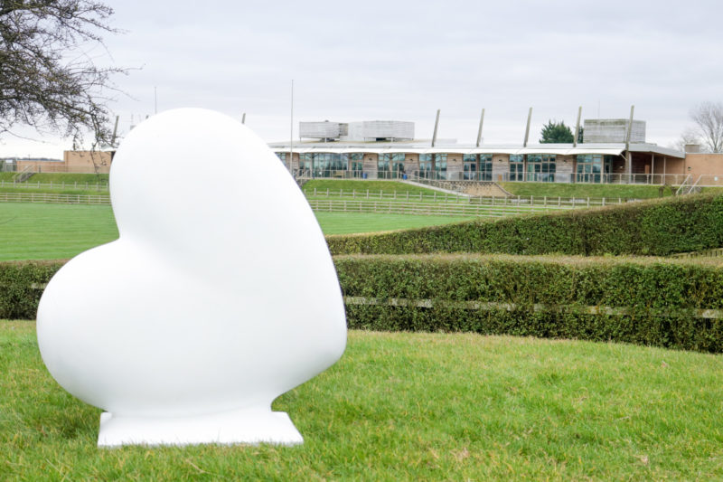 Large white heart-shaped statue with Lincolnshire Showground in background