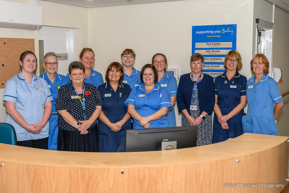 A group of nurses standing behind a reception in a hospice